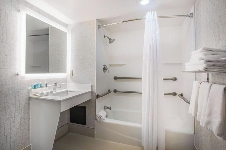 Refresh yourself in a bright, accessible bath with fluffy towels.