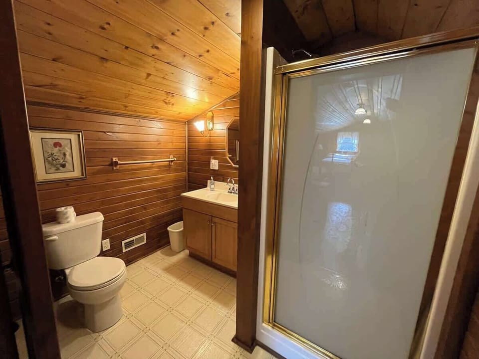 The upstairs bathroom features bright vanity lighting and a shower, perfect for those staying in the upstairs bedroom.