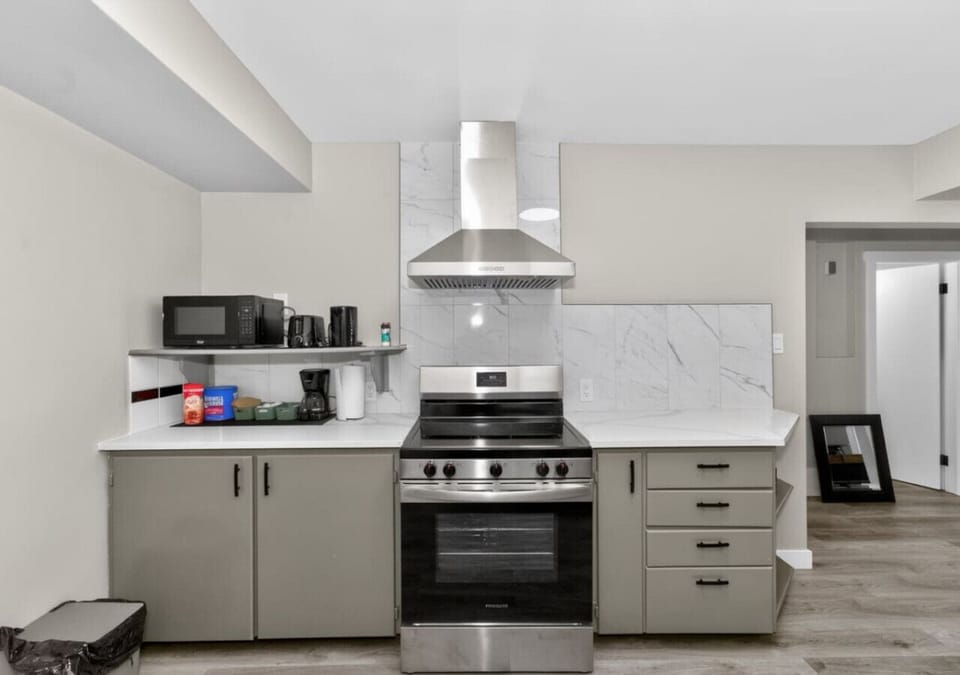 Fully equipped kitchen with stainless steel stove, microwave, and ample storage.