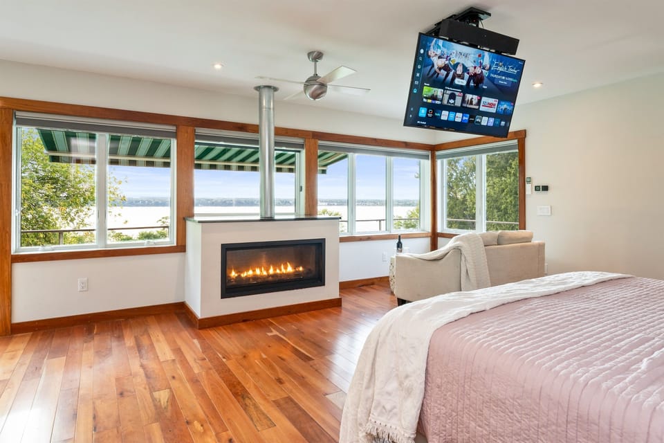 Bedroom with fireplace and wraparound windows