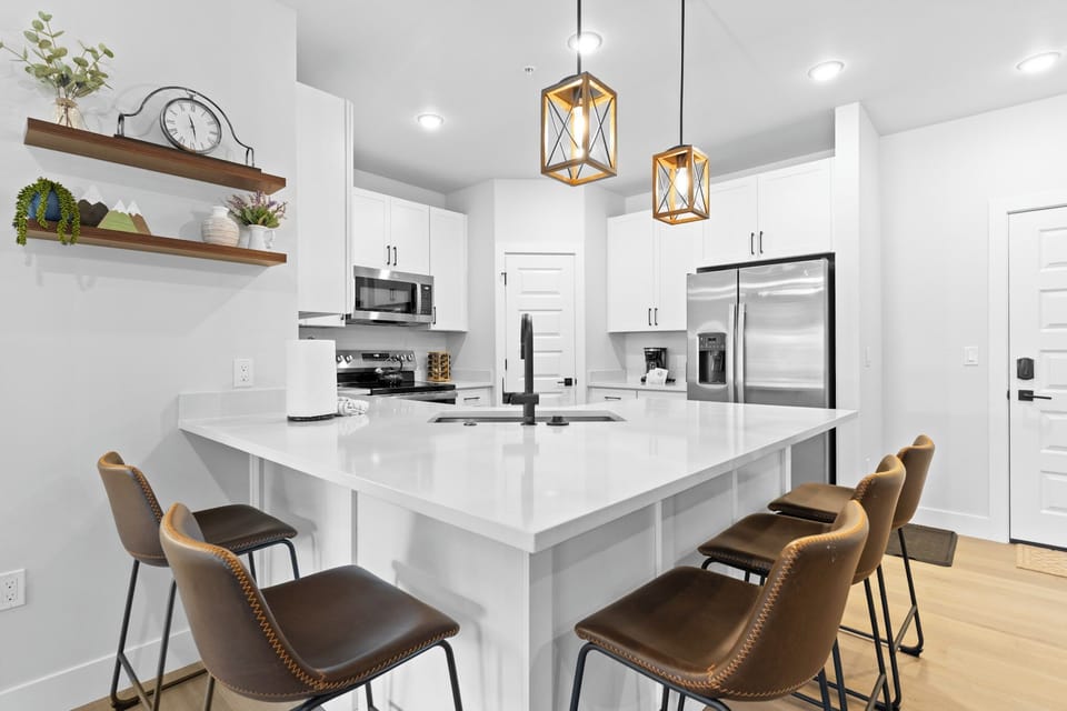 Full kitchen featuring stainless steel appliances and a breakfast bar with seating for five.