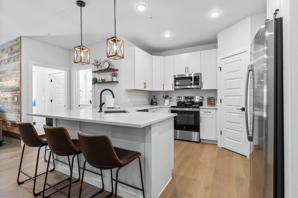Full kitchen featuring stainless steel appliances and a breakfast bar with seating for five.