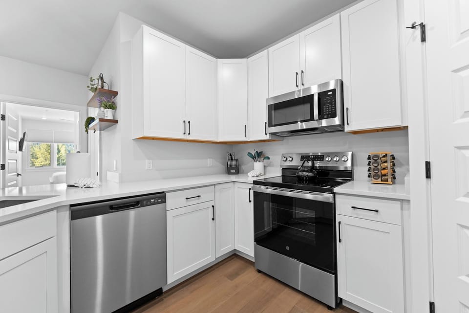 Full kitchen featuring stainless steel appliances and a breakfast bar with seating for five.