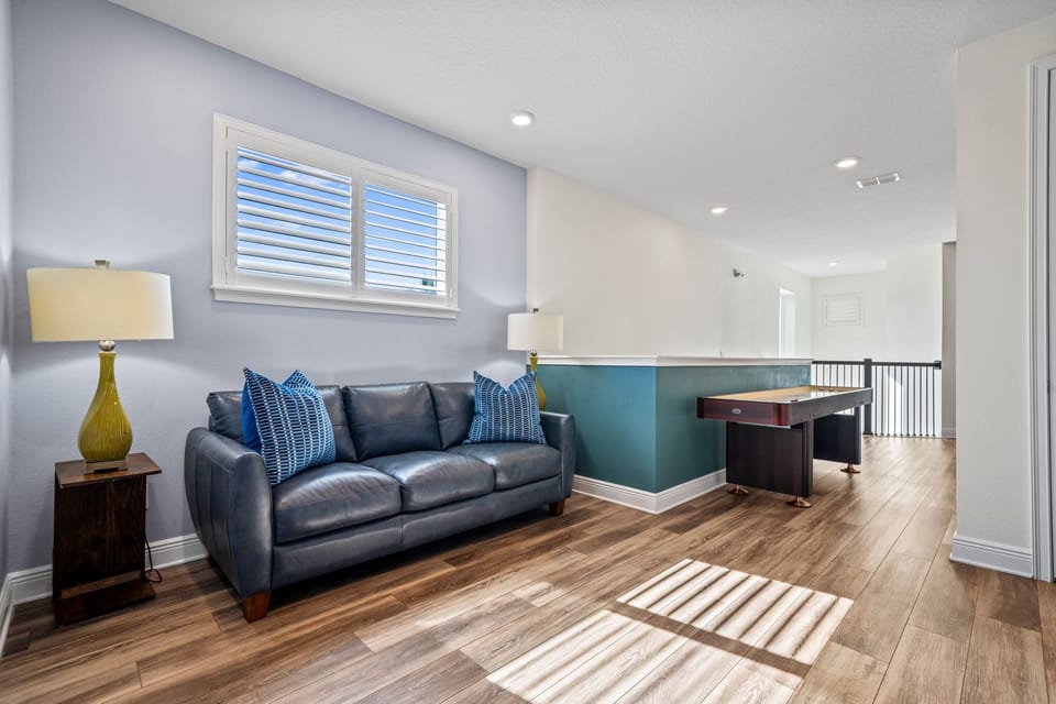 A versatile loft designed for both play and relaxation, combining shuffleboard fun with comfortable seating and TV viewing.