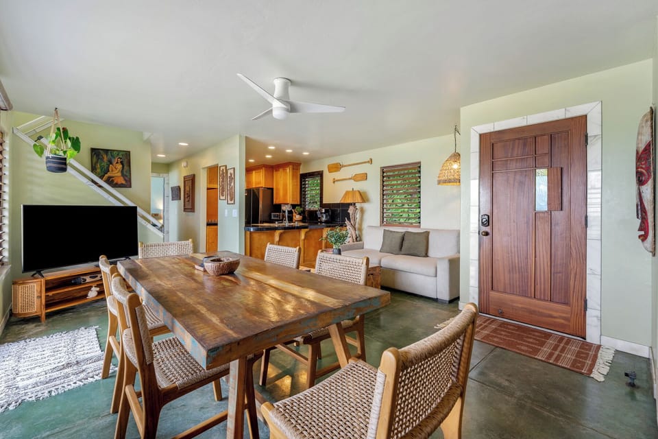 Gather around your wood dining table with woven chairs, where tropical breezes flow through your open-concept living space.