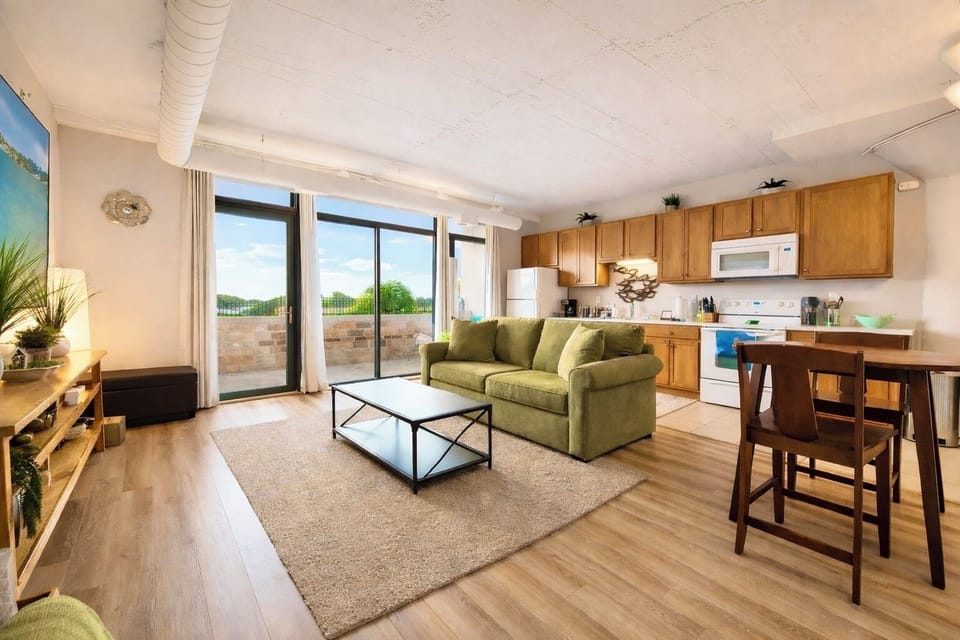 Sun-filled open living space with comfortable seating, full kitchen, and patio access. Natural light, warm finishes, and an inviting layout create the perfect place to relax after exploring the area.