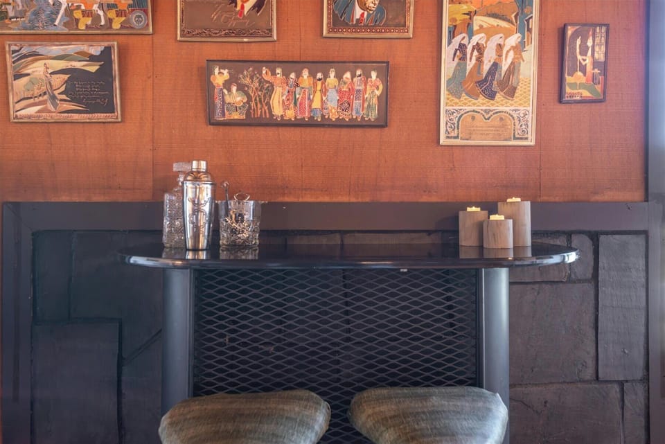 Step into your own private bar corner, where vintage artwork meets classic cocktail culture for unforgettable evening conversations.