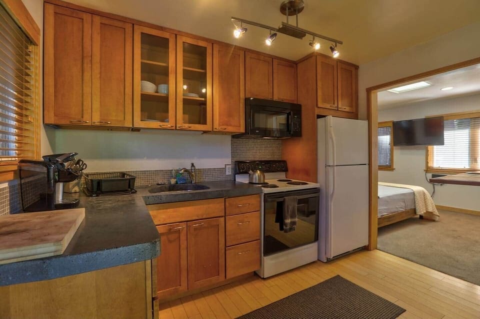 Cement counter tops, fully furnished with pots, pans, dishes and a Kurig