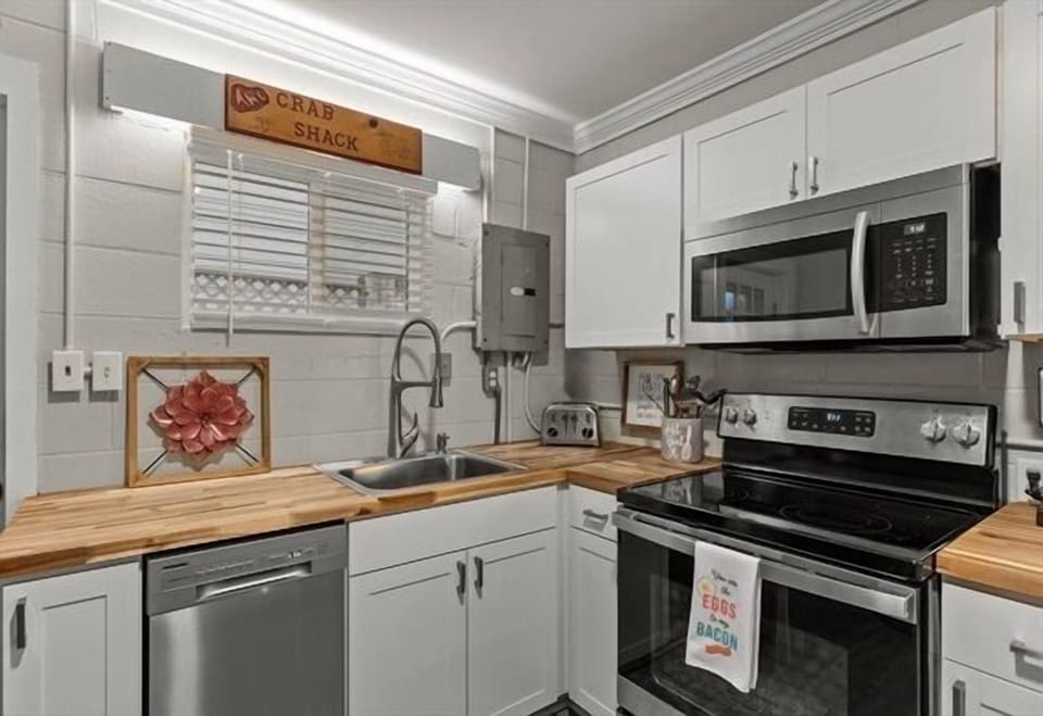 Your fully equipped kitchen awaits with warm wood countertops, stainless appliances, and charming coastal touches for memorable home-cooked meals.