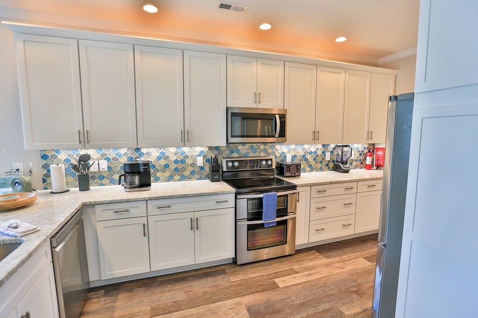 You'll love cooking in this bright kitchen with stainless steel appliances, colorful backsplash, and plenty of cabinet space for all your vacation meal prep needs.