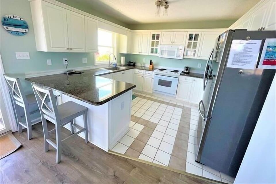Your spacious kitchen features granite countertops, white cabinetry, and modern appliances where you can prepare memorable meals with loved ones.