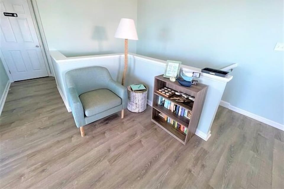 Settle into your peaceful reading nook with soft lighting and a curated book collection at your fingertips.