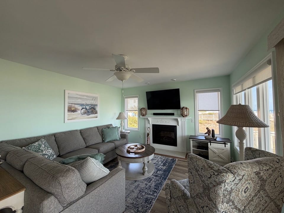 Sink into coastal comfort in your serene living room, where soft mint walls and plush seating create the perfect retreat after beach days.