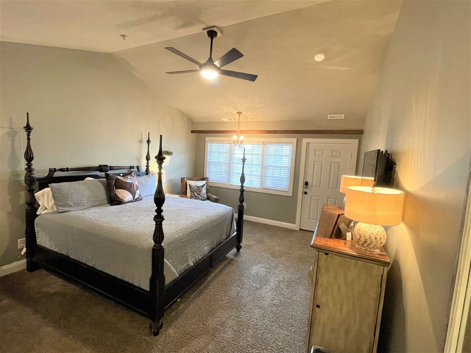 Sink into your elegant four-poster bed with plush linens while the ceiling fan creates a gentle breeze overhead.