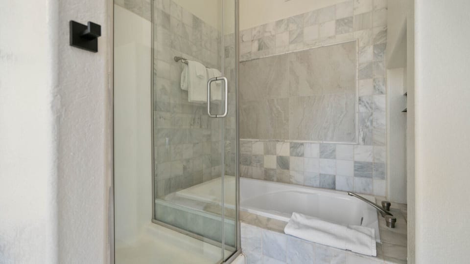 Modern bathroom featuring a spacious glass-enclosed shower with elegant tile finishes and a fresh, contemporary design for a comfortable stay.