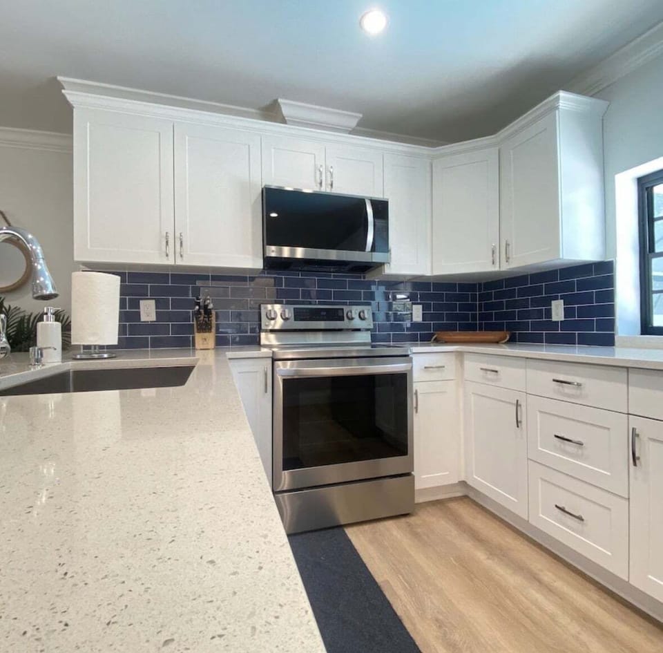 Modern Design: Featuring crisp white cabinetry, quartz countertops and a beautiful blue backsplash