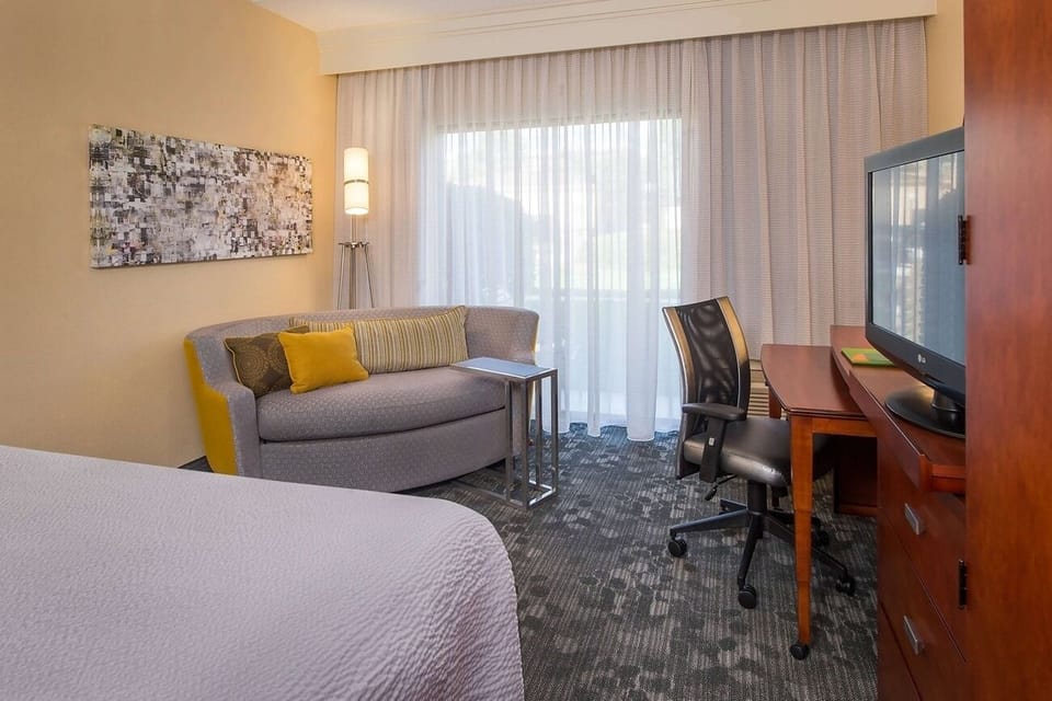 Unwind in a bright room with sofa, desk, and TV.