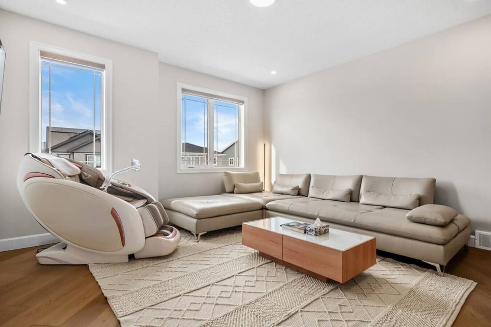 Spacious living room with large sectional sofa and two bright windows