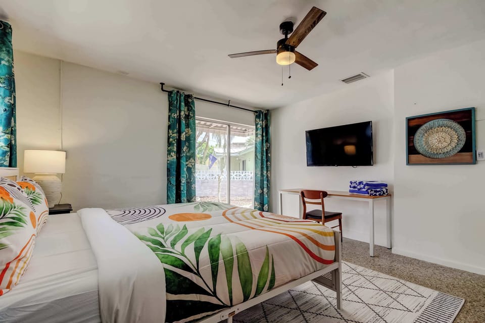 Bright bedroom with tropical bedding and TV