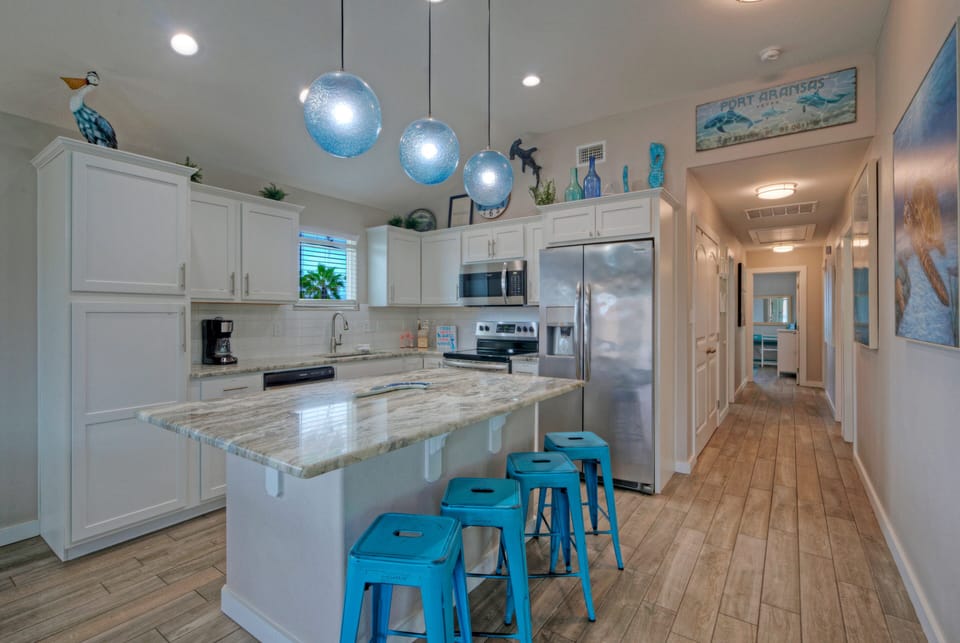 Modern kitchen with generous counter space, bar seating, and everything needed for easy vacation meals.
