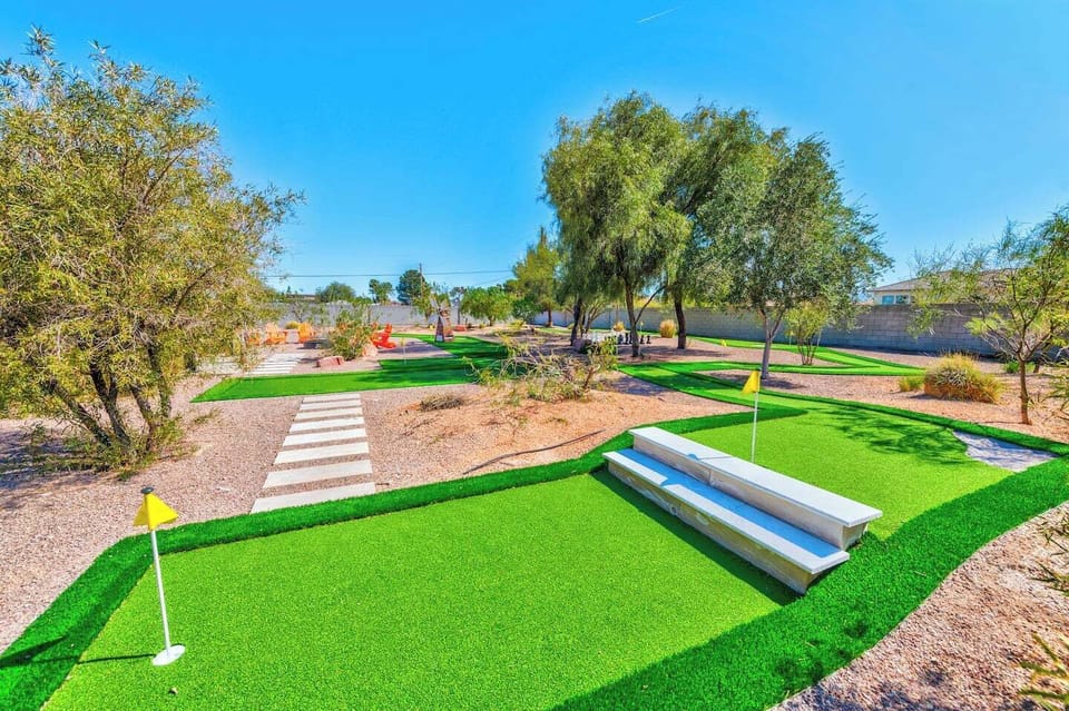 Hole 9 of the backyard 9-hole mini golf course, winding through desert landscaping and shaded trees.