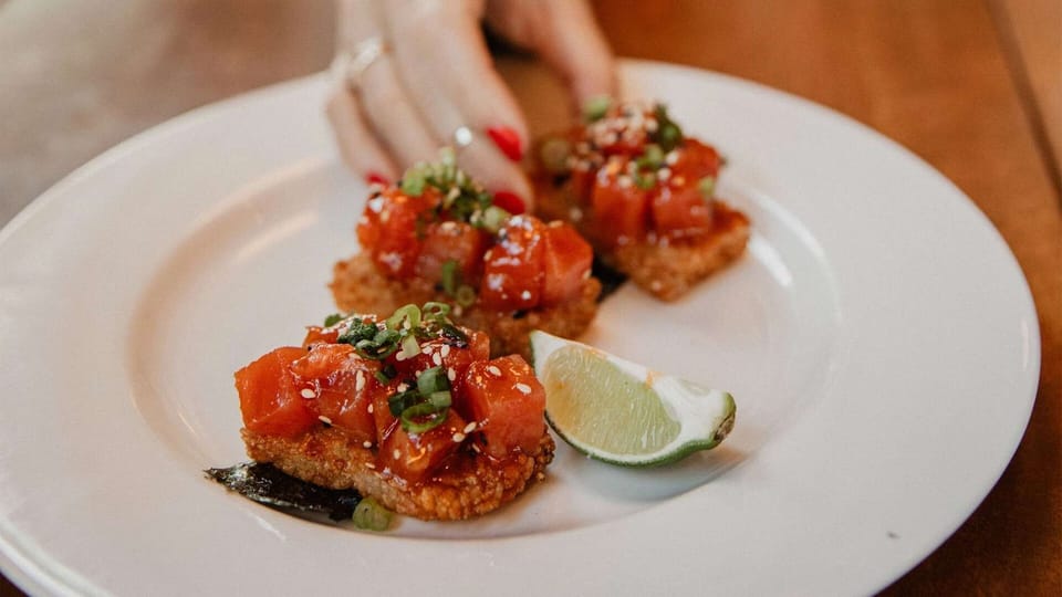 Seared tuna bites with sesame, scallions, and lime wedge
