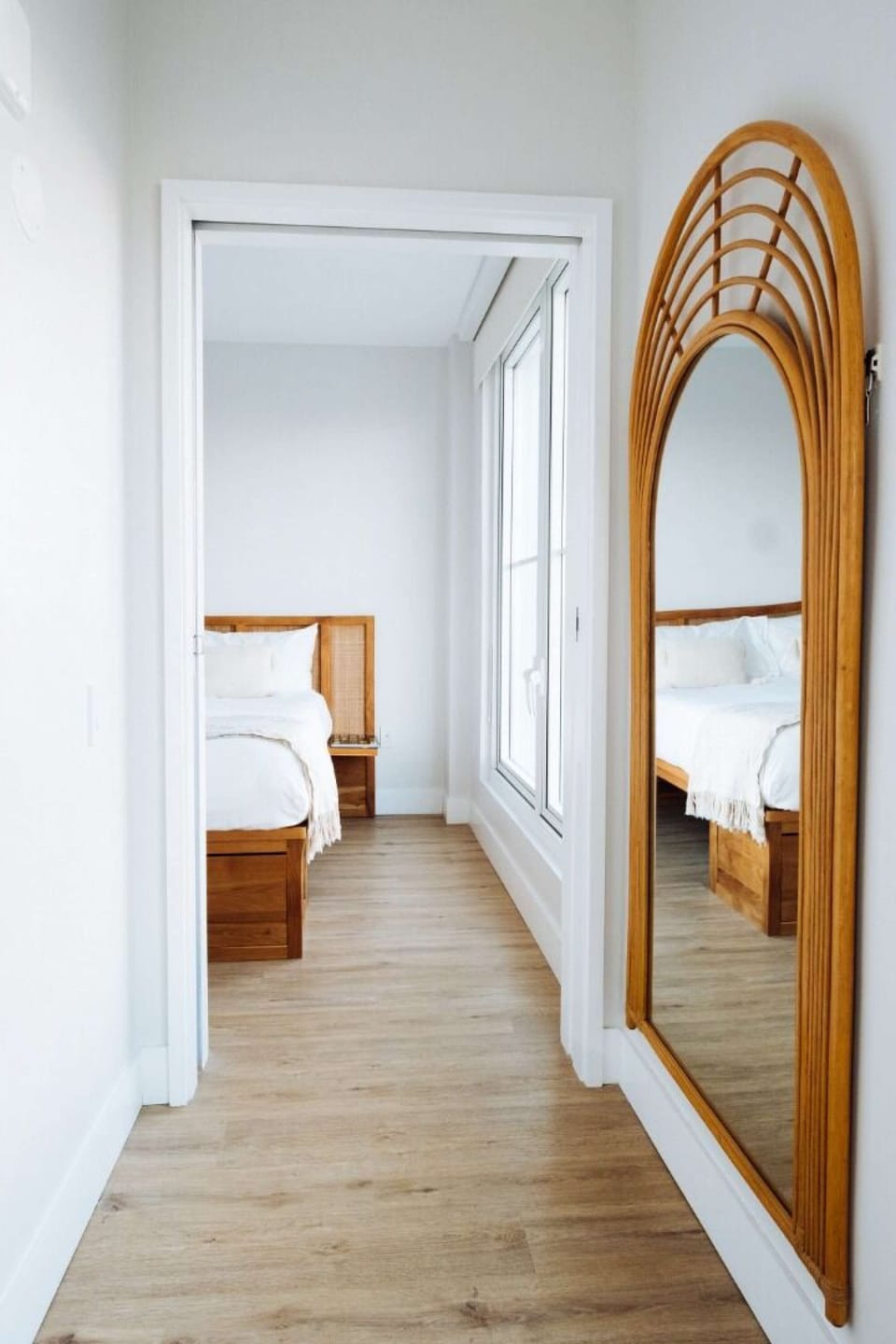 One Bedroom Bungalow - Hallway with arched mirror and wood bed frame