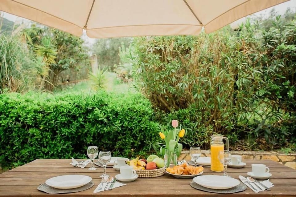 Shared garden breakfast area surrounded by greenery.