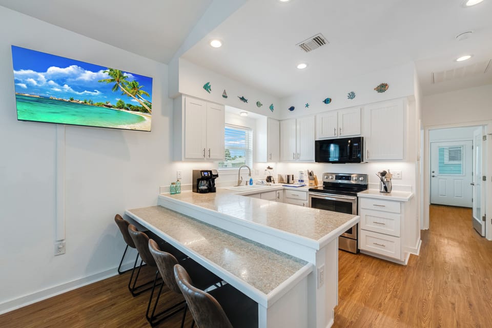 Your gourmet kitchen features modern appliances, granite counters, and a breakfast bar perfect for morning coffee with ocean views.