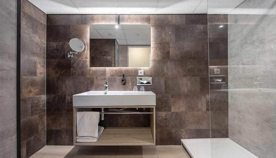 Refresh in a sleek, spa-like bathroom with bright vanity lighting.