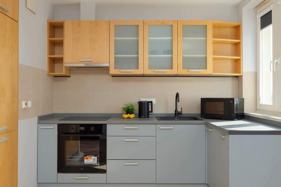 A close-up of modern kitchen cabinets with a built-in range hood and glass-fronted upper cabinets.