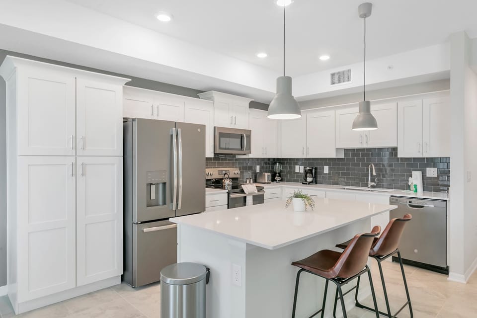 Prepare meals with ease in this bright, modern space featuring premium stainless steel appliances and sleek subway tile.