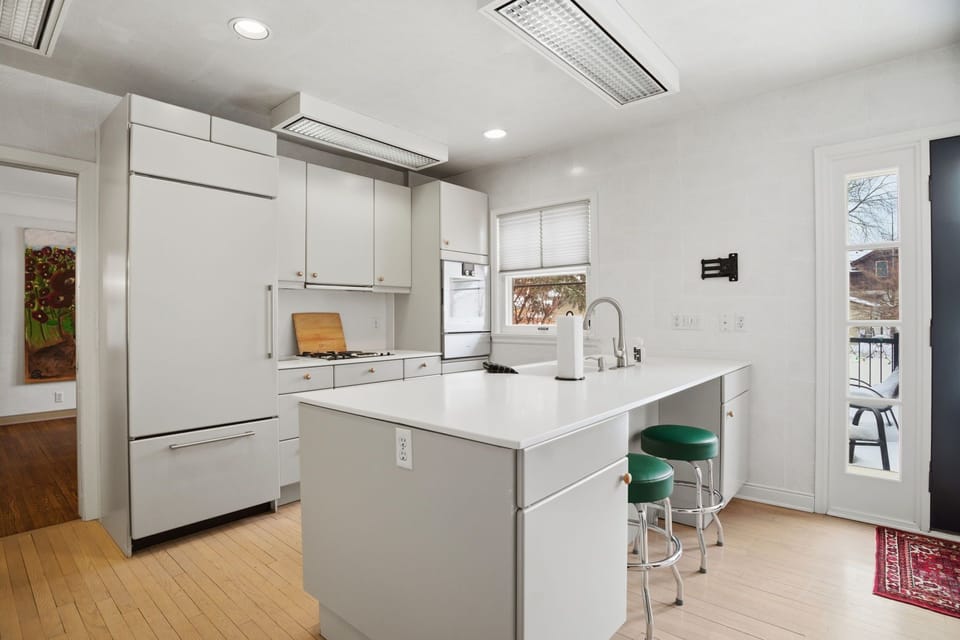 Your sleek modern kitchen features pristine white countertops, premium appliances, and a breakfast island where you'll start each morning perfectly.