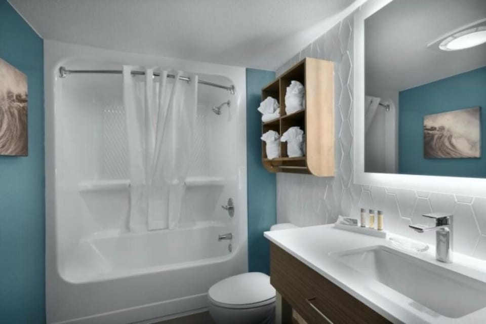 Refresh in a spotless bath with bright vanity lighting.