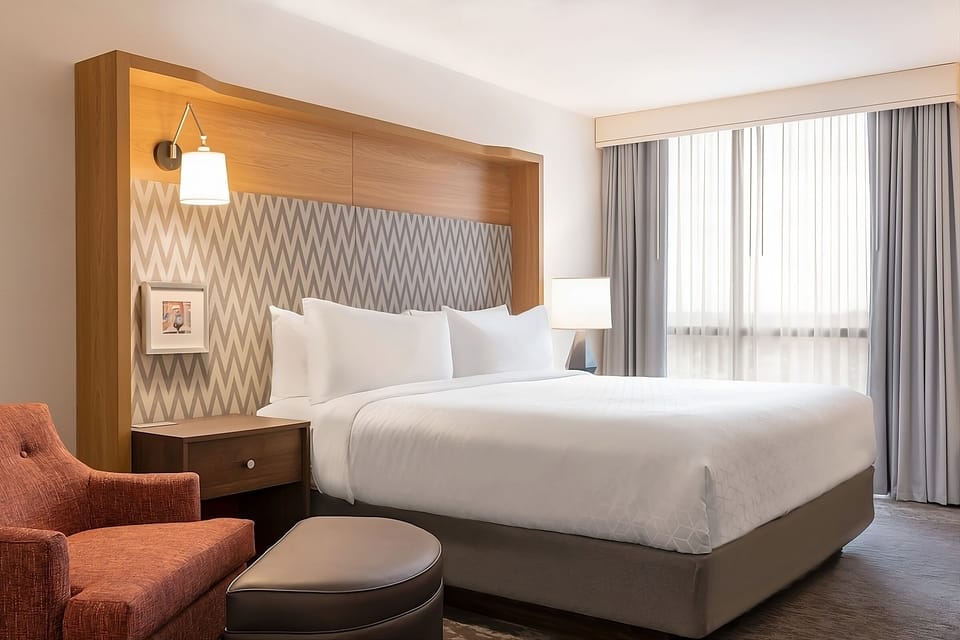 Sink into crisp linens beneath a warm, designer headboard.