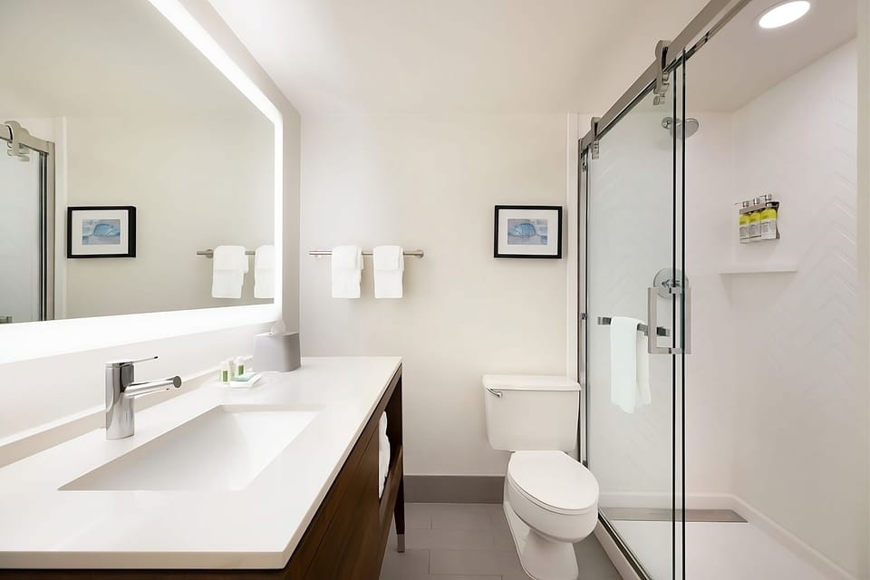 Rinse off in a sleek glass shower with bright lighting.
