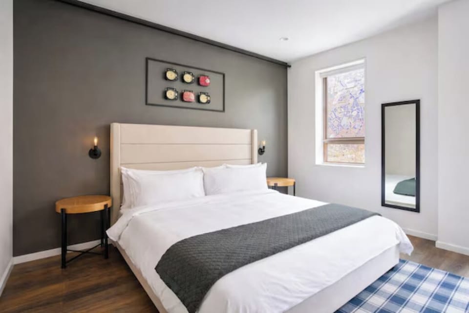 Unwind in crisp linens beneath warm bedside lighting.