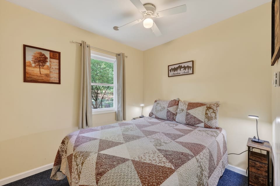 Inviting queen bedroom with peaceful woodland views.