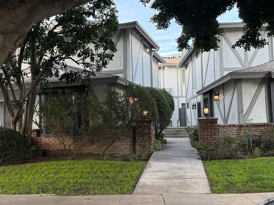 Tucked away in a charming Tudor-style complex surrounded by mature trees and manicured hedges — a quiet, picturesque setting that feels like a peaceful escape right in the heart of the city.