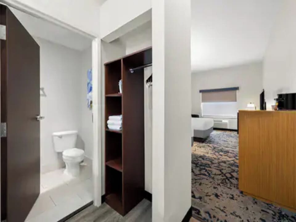 Step into a convenient entryway with shelving and bathroom access.