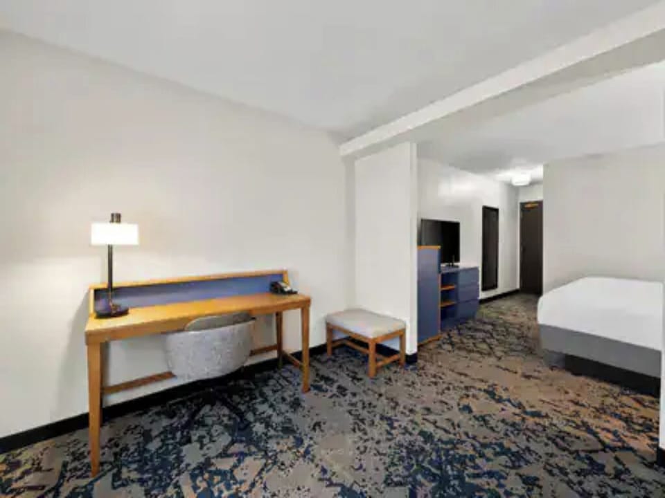 Enjoy a spacious room layout with dedicated desk and restful bed.