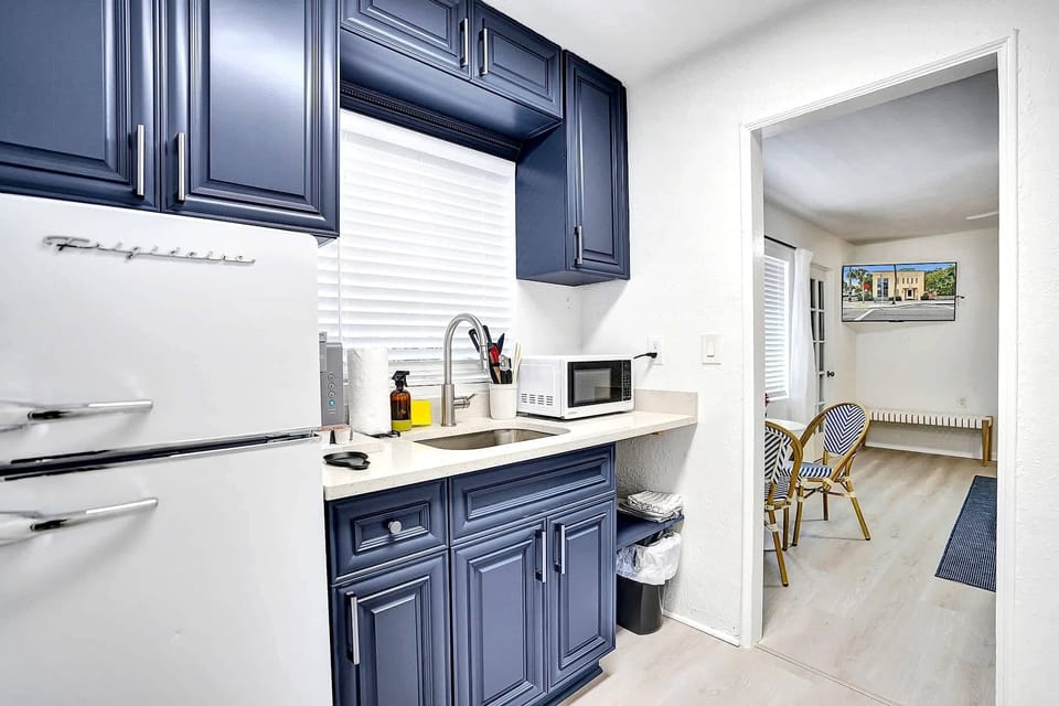 Blue kitchenette with fridge, sink, and microwave