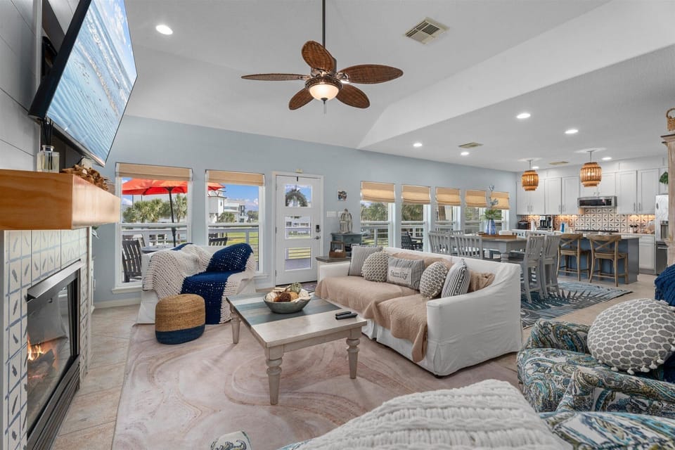 Large open-concept living space featuring coastal decor, comfortable seating, and modern lighting.