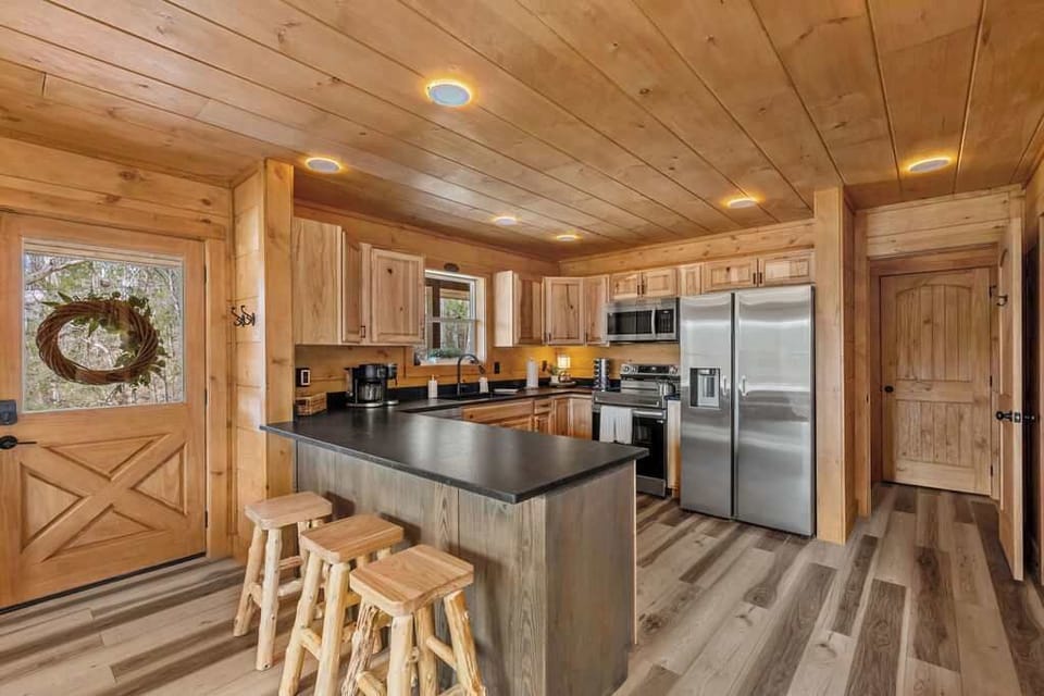 Spacious Kitchen with Granite Countertops and Stainless Steel Appliances. 3 Barstools in Kitchen Area. Seating 10 Comfortably. 