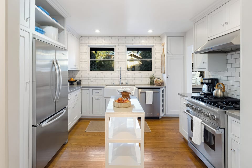 Light-filled kitchen with a farmhouse sink, stainless steel appliances, and clean modern finishes.