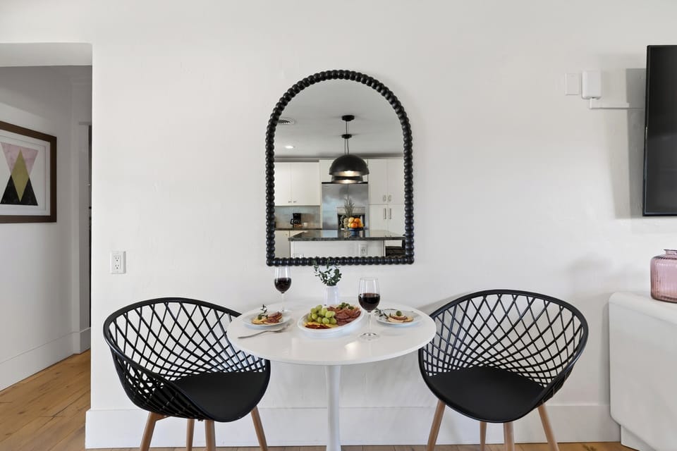 Chic circular table with a statement arched mirror and designer seating.