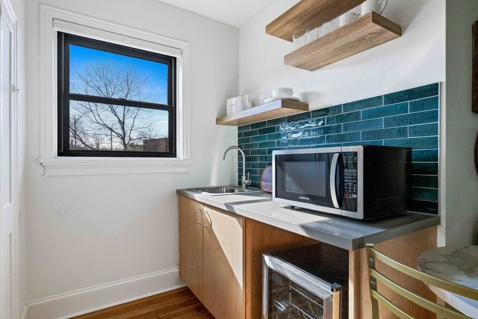 Enjoy the convenience of a well-equipped kitchenette featuring a mini fridge, microwave, sink, coffee maker, and open shelving — ideal for preparing light meals and morning coffee during your stay. Layout and shelving may vary slightly by unit.