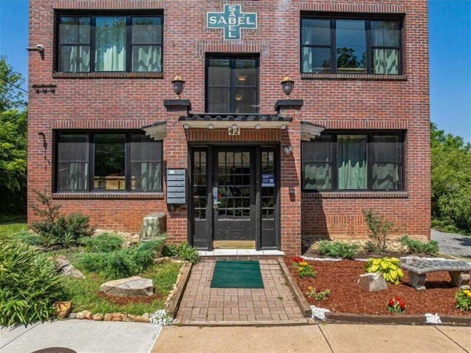 Charming brick building nestled in greenery, offering a peaceful and convenient stay.