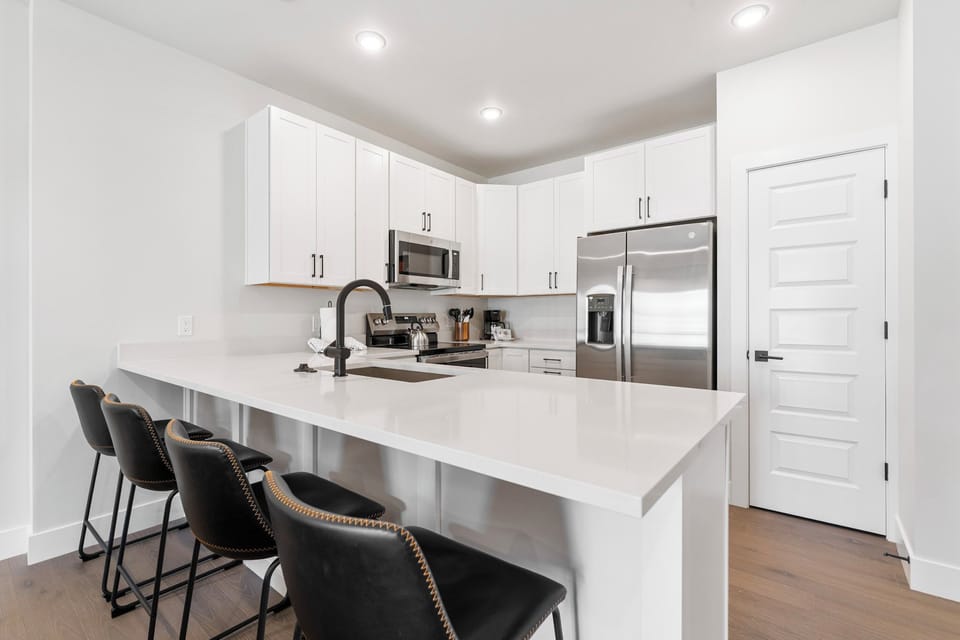 Full kitchen with stainless steel appliances and breakfast bar.