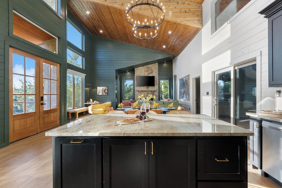 Bright, open kitchen with soaring ceilings, large island seating, and seamless flow into the living space